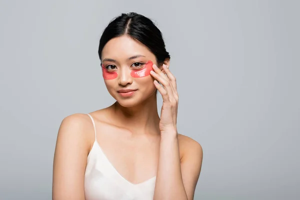 Asiatin in Augenklappen und Satinkleid posiert isoliert auf grau — Stockfoto
