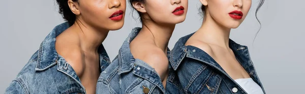 Cropped view of interracial women in denim jackets isolated on grey, banner — Stock Photo