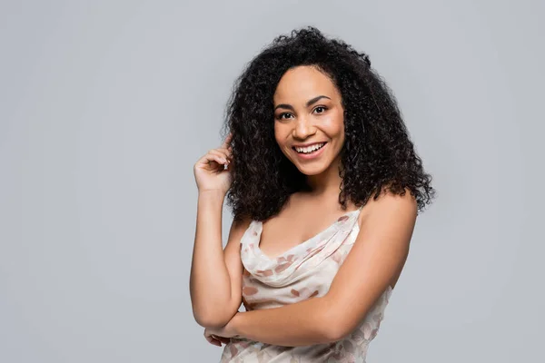 Cheerful african american woman looking at camera isolated on grey — Stock Photo