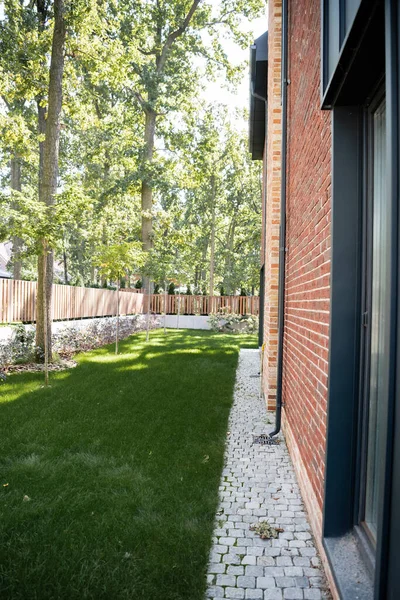 Soleil sur la cour arrière avec pelouse verte près de la maison moderne — Photo de stock