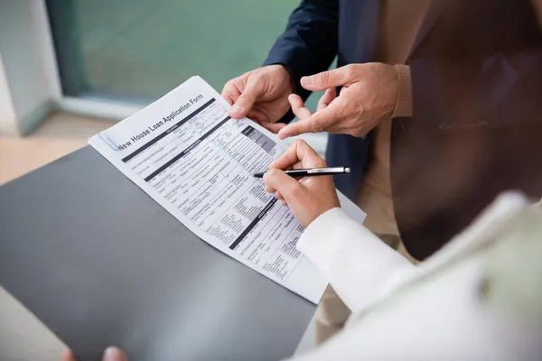 Cropped view of woman signing contract near realtor — Stock Photo