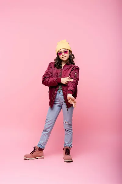Longitud completa de la chica preadolescente con estilo en traje de moda posando en rosa — Stock Photo