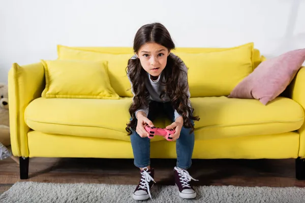 KYIV, UKRAINE - SEPTEMBER 17, 2021: tensed preteen girl playing video game at home — Stock Photo