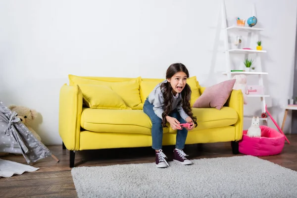 KYIV, UKRAINE - SEPTEMBER 17, 2021: preteen girl screaming while playing video game at home — Stock Photo