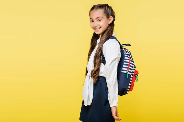 Glückliches Frühchen mit Rucksack blickt isoliert auf gelb in die Kamera — Stockfoto