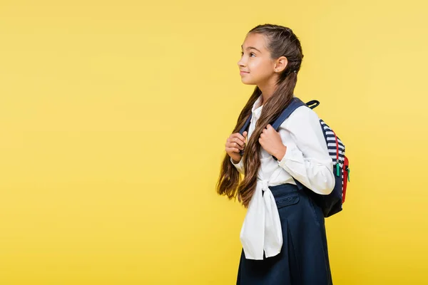 Preteen pupil holding backpack isolated on yellow — Stock Photo