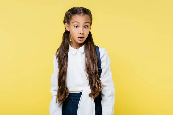 Amazed schoolkid with backpack looking at camera isolated on yellow — Stock Photo