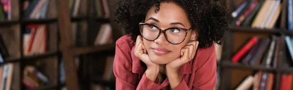 Verträumte afrikanisch-amerikanische Frau mit Brille, die wegschaut, Banner — Stockfoto