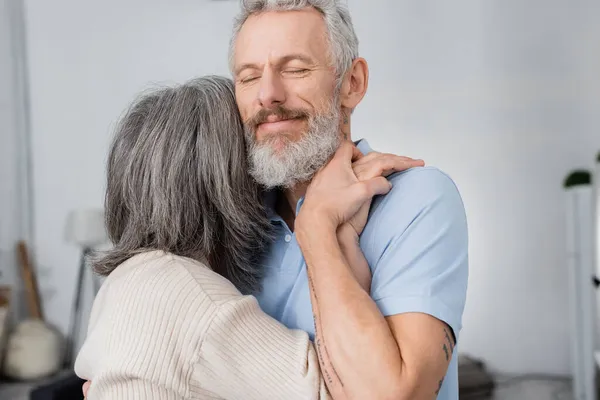 Barbuto uomo che tiene la mano della moglie a casa — Foto stock