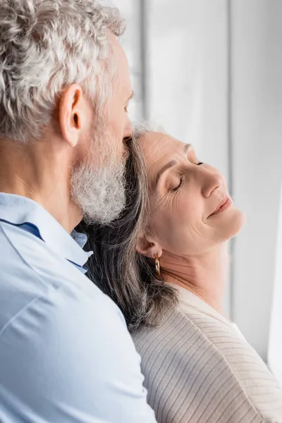 Reifer Mann küsst Ehefrau zu Hause — Stockfoto