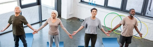 High angle view of senior multiethnic people doing yoga pose in sports center, banner — Stock Photo