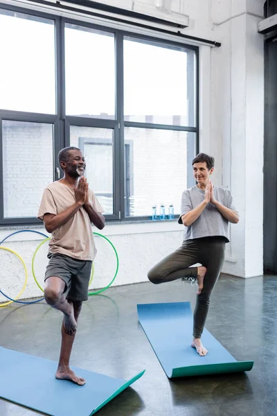 Personas multiétnicas posando sobre esteras de yoga en un centro deportivo - foto de stock