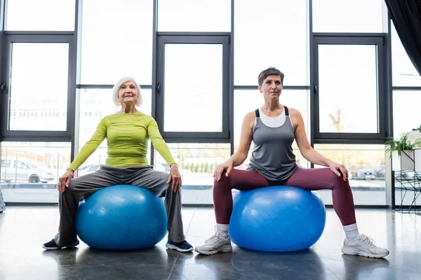 Elderly sportswomen training on fitness mats in gym — Stock Photo