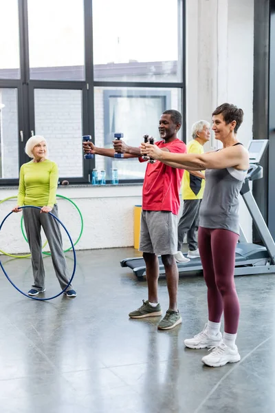 Formation de personnes âgées multiethniques avec équipement sportif dans un centre sportif — Photo de stock