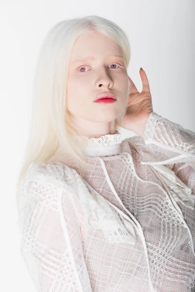 Молода альбіносова жінка в гіпюровій блузці дивиться на камеру ізольовано на білому — стокове фото