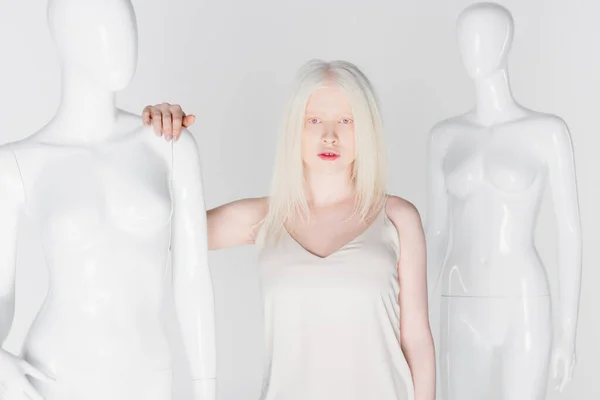 Jolie femme blonde et albinos debout près de mannequins isolés sur blanc — Photo de stock