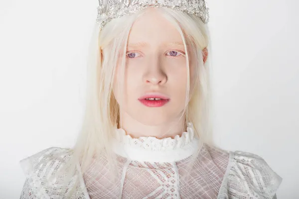Junge Albino-Frau in Guipure-Bluse und Krone schaut vereinzelt auf weißem Grund weg — Stockfoto