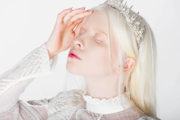 Молода альбіносова жінка в короні з дорогоцінними каменями закриваються очі ізольовані на білому — стокове фото