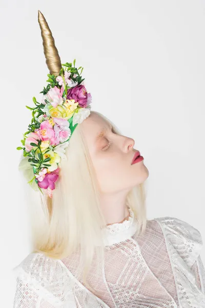 Modelo albino en corona con flores cerrando los ojos aislados en blanco - foto de stock