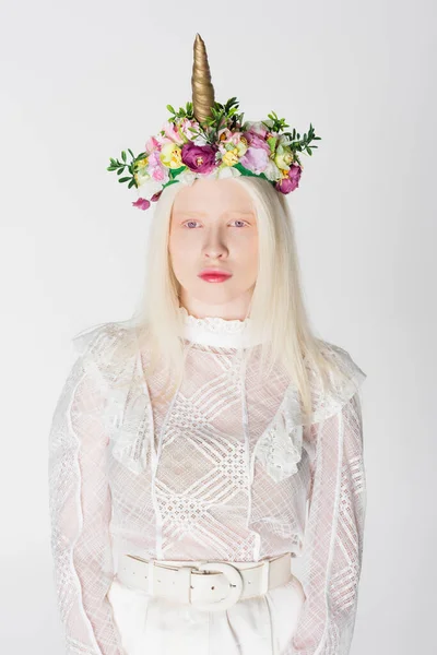 Femme albinos élégante en chemisier guipure et couronne de fleurs et corne isolée sur blanc — Photo de stock