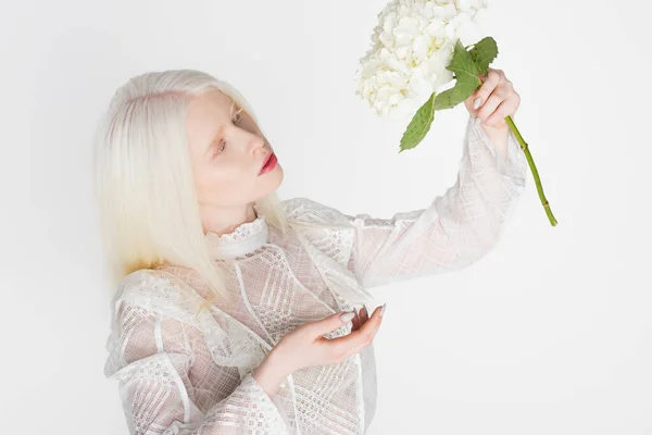 Mujer albina en blusa guipure sosteniendo flor de hortensia aislada en blanco - foto de stock