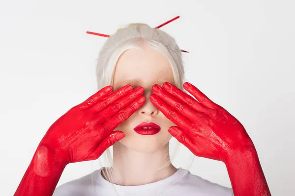 Female hands in paint covering eyes of albino model isolated on white — Stock Photo