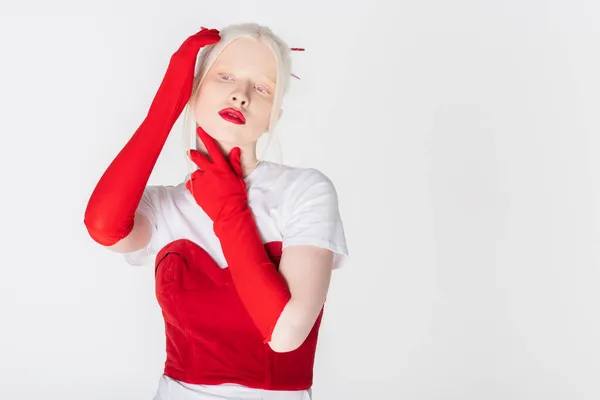 Modelo Albino com lábios vermelhos e luvas tocando pescoço isolado em branco — Fotografia de Stock