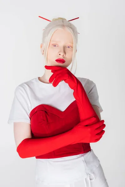 Стильна альбіносова жінка в червоних рукавичках і паличках для волосся ізольована на білому — стокове фото