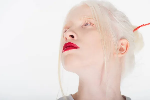 Портрет женщины-альбиноса с красными губами, смотрящей вдаль на белый — стоковое фото