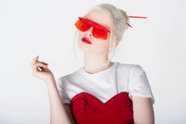 Pretty albino model in red sunglasses and hair sticks isolated on white — Stock Photo