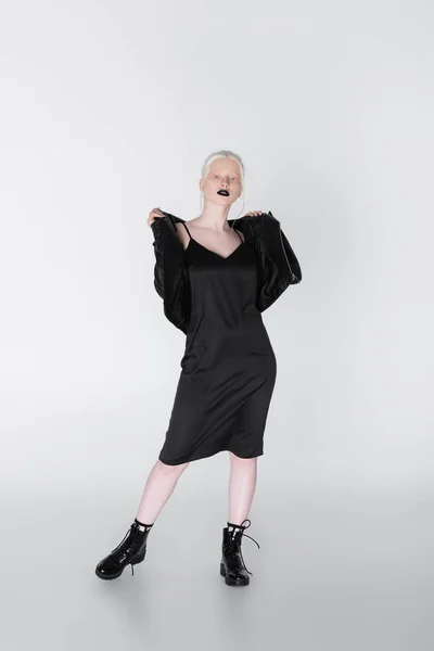 Volle Länge der stilvollen Albino-Frau in schwarzem Kleid und Jacke auf weißem Hintergrund — Stockfoto