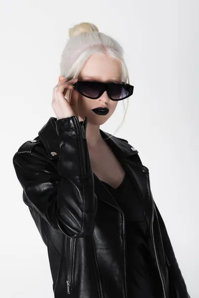 Modelo albino de moda en chaqueta de cuero negro con gafas de sol aisladas en blanco - foto de stock