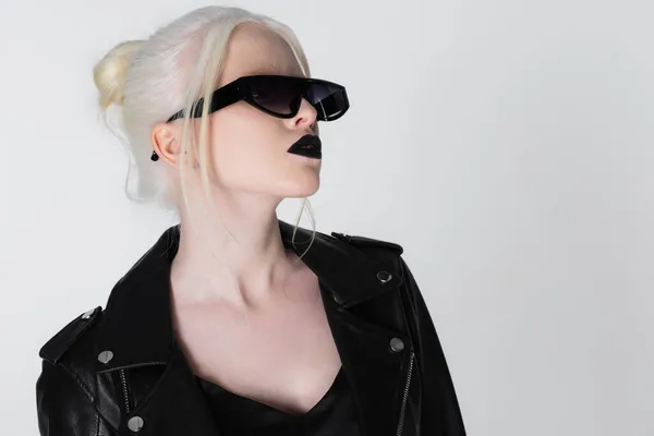 Femme albinos à la mode en lunettes de soleil noires et veste en cuir isolée sur blanc — Photo de stock