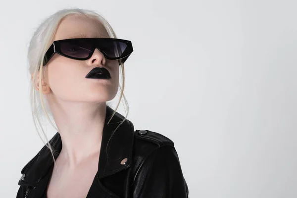 Retrato de modelo albino en chaqueta de cuero y gafas de sol aisladas en blanco - foto de stock