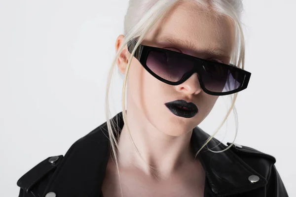 Donna albino alla moda in occhiali da sole e giacca di pelle isolata su bianco — Foto stock