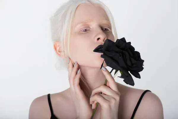 Pretty albino model with black lips holding rose isolated on white — Stock Photo