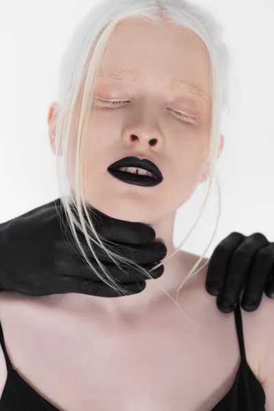 Mãos masculinas em tinta preta tocando albino mulher isolada em branco — Fotografia de Stock