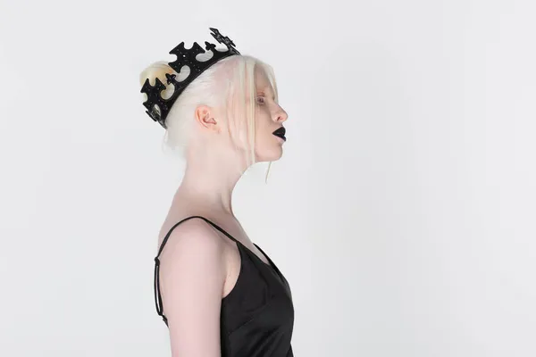 Seitenansicht einer Albino-Frau in schwarzer Krone, die isoliert auf weißem Grund steht — Stockfoto