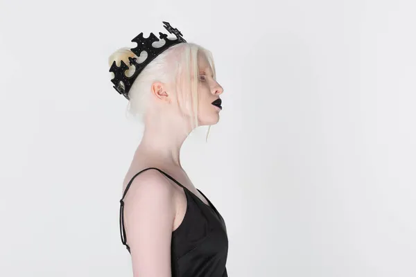Side view of albino woman in black crown standing isolated on white — Stock Photo