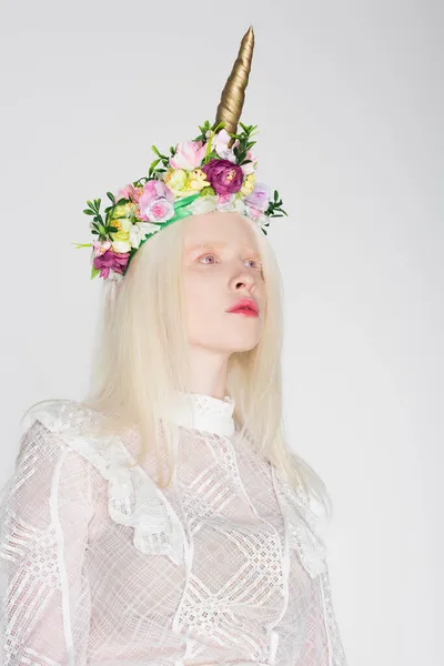 Albino-Modell in Bluse und Blumenkranz schaut vereinzelt auf weißem Grund weg — Stockfoto