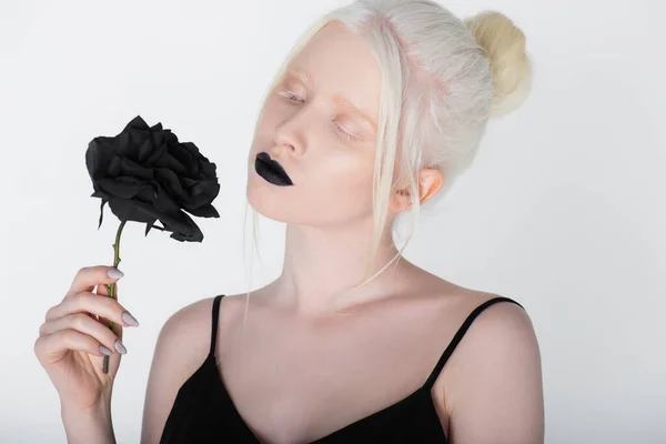 Pretty albino woman with black lips holding rose isolated on white — Stock Photo