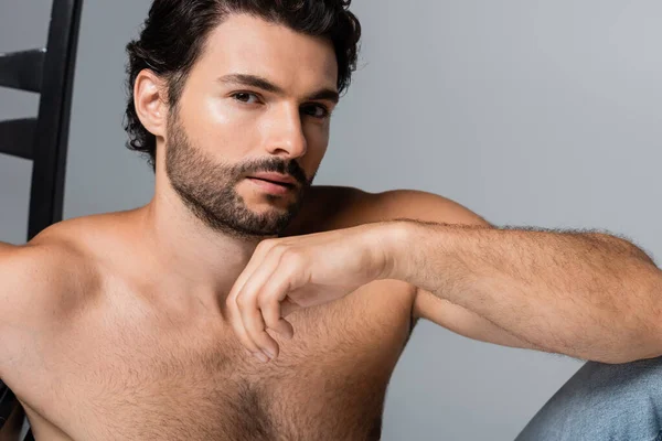 Giovane uomo senza maglietta in posa mentre guarda la fotocamera isolata sul grigio — Foto stock