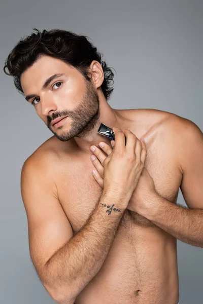 Jeune homme tatoué taille barbe isolé sur gris — Photo de stock