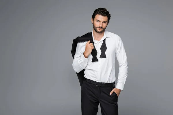 Bärtiger Mann im Anzug mit Blazer im Stehen mit der Hand in der Tasche isoliert auf grau — Stockfoto
