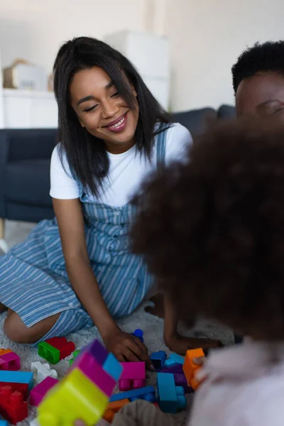 Flou afro-américain enfant jouer blocs de construction jeu avec mère heureuse et mamie — Stock Photo