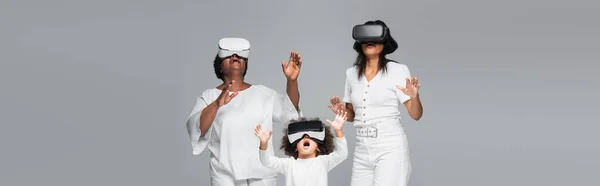 Amazed african american women and child gaming in vr headsets isolated on grey, banner — Stock Photo