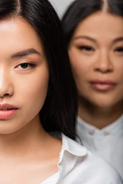 Close up of asian young adult daughter near blurred mother standing behind — Stock Photo