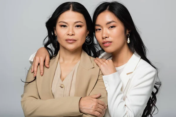 Asiatique mère et fille embrassant isolé sur gris — Photo de stock