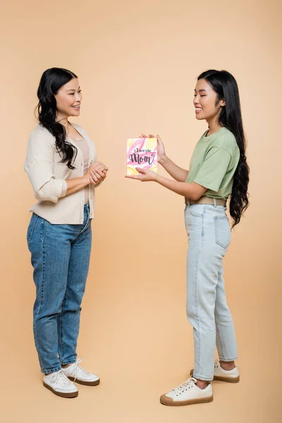 Glücklich asiatische Frau geben Grußkarte mit ich liebe dich Mama Schriftzug zu Mutter auf beige — Stockfoto