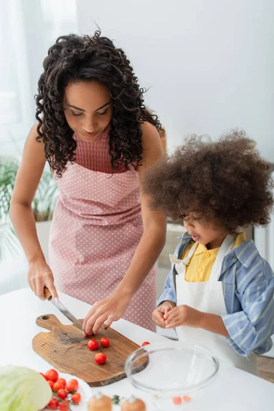 Afrikanische amerikanische Mutter und Kind kochen Salat in der Küche — Stockfoto